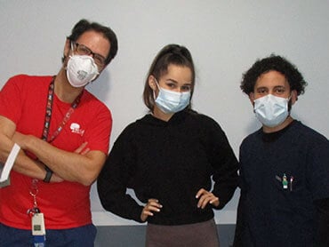 Cristine Chinea standing with her physical therapists.