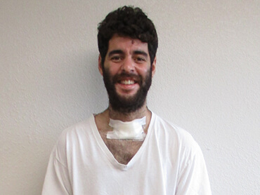 Joseraul stands and smiles after therapy.