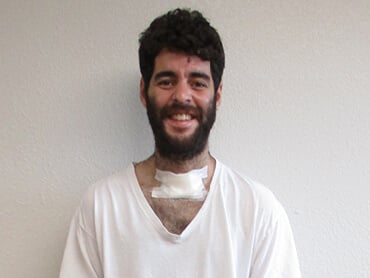 Joseraul stands and smiles after therapy.