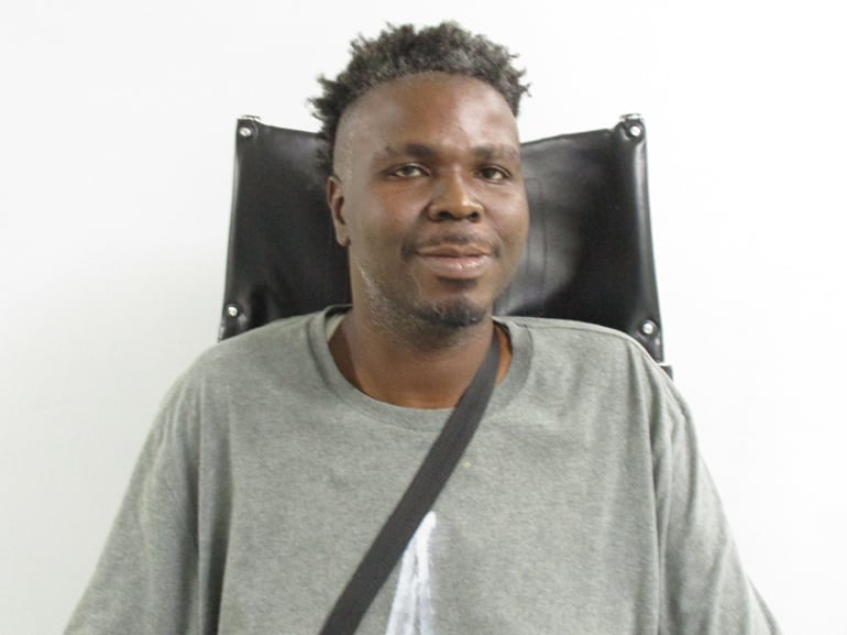 Michael Kirk smiles while sitting in a chair.