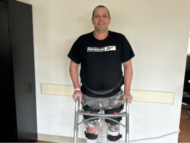 Yunior standing in front of white wall with walker