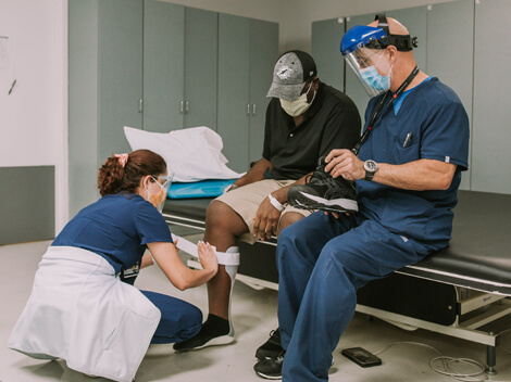 Two treatment team members administering care to a male patient