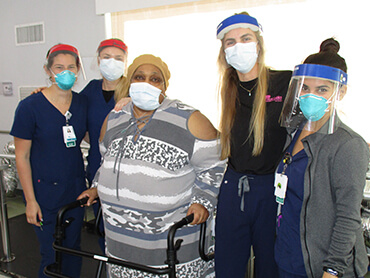 a photo of Paula Davis, standing beside her team of therapists